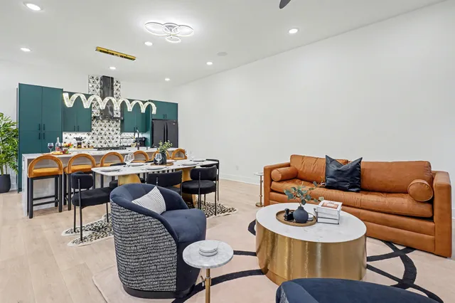 a living room with furniture a chandelier and kitchen view