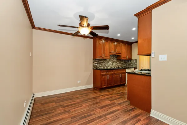 a kitchen with stainless steel appliances granite countertop a sink and a stove with wooden floor