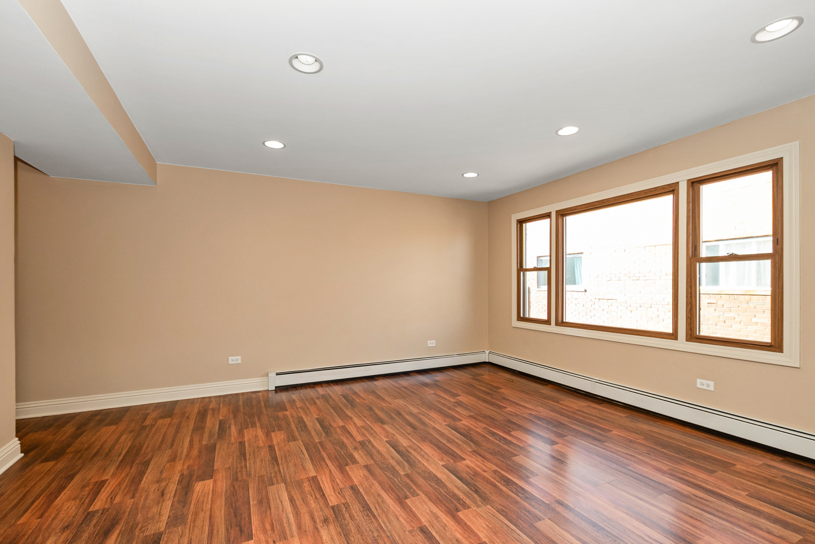 10625 Parkside Avenue, Unit 8 Chicago Ridge, IL 60415 - Photo 9 of 16 an empty room with wooden floor and windows