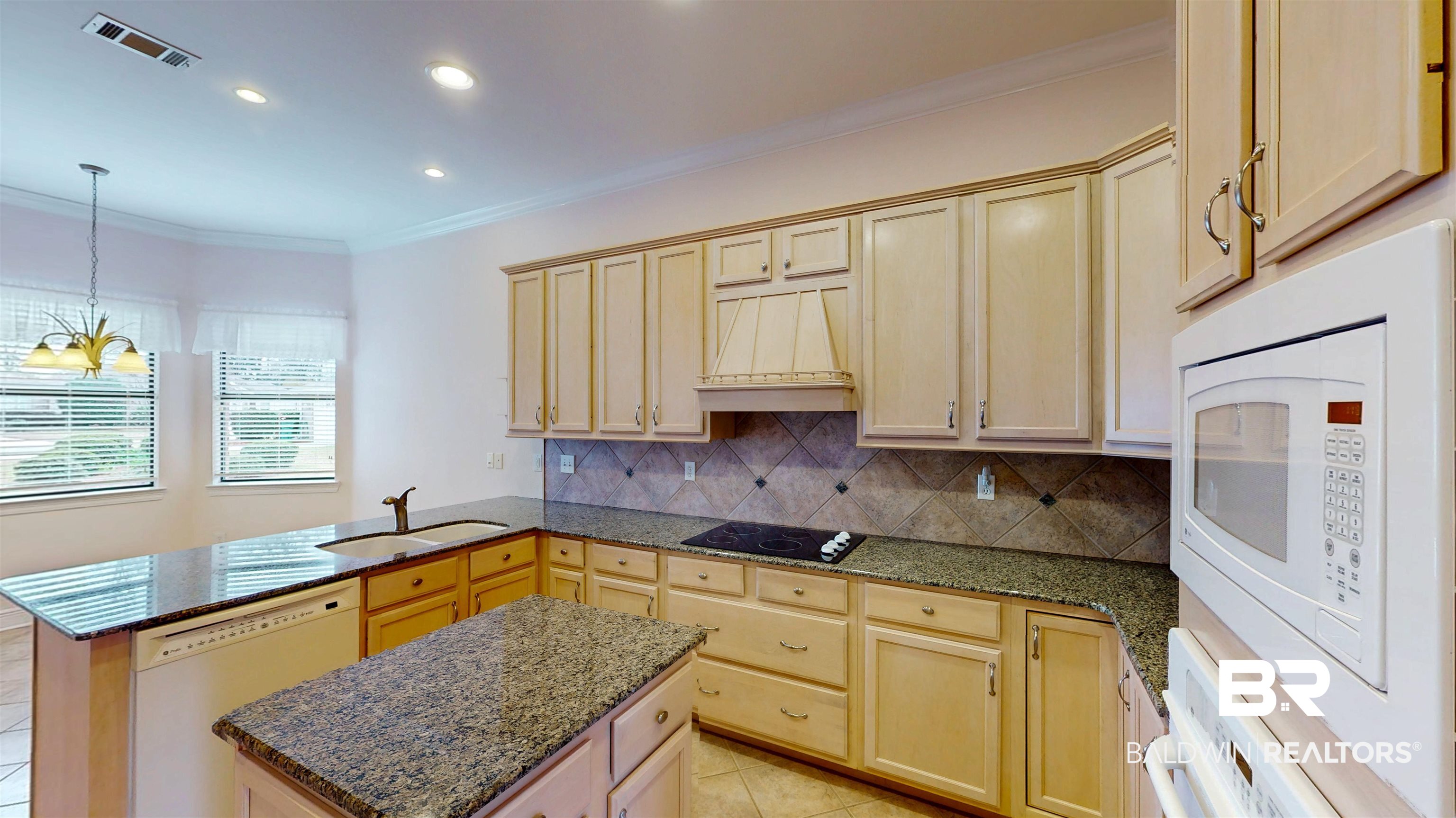 214 Hemingway Loop Foley, AL 36535 - Photo 13 of 67 Kitchen with white appliances, ornamental molding, a peninsula, light brown cabinets, and custom range hood