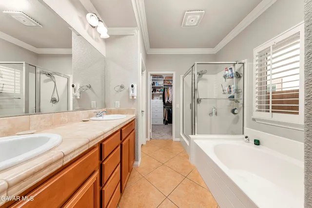 a spacious bathroom with a tub sink shower and a mirror