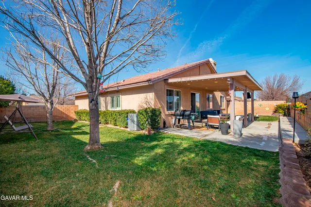 a view of a house with backyard and sitting area