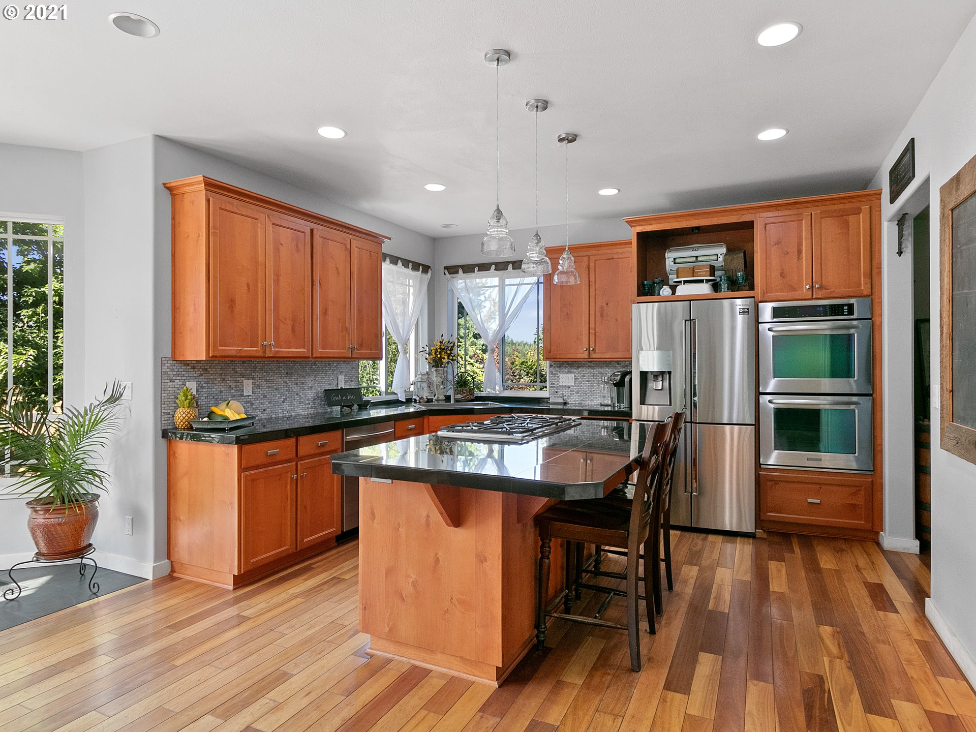 35412 Southeast Shade Tree Lane Estacada, OR 97023 - Photo 7 of 32 a kitchen with stainless steel appliances granite countertop a refrigerator a sink dishwasher a stove and a dining table with wooden floor
