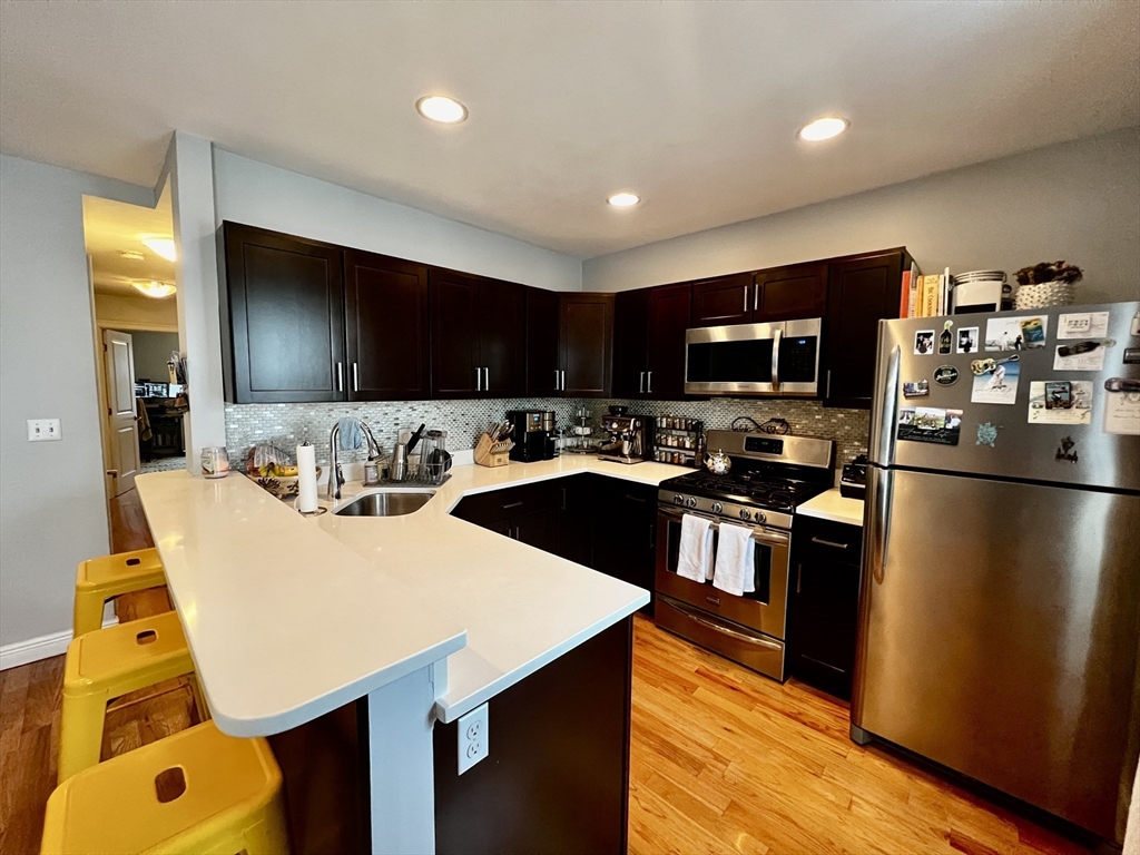 a kitchen with stainless steel appliances granite countertop a sink refrigerator and microwave