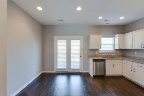 a kitchen with granite countertop a sink and wooden floor