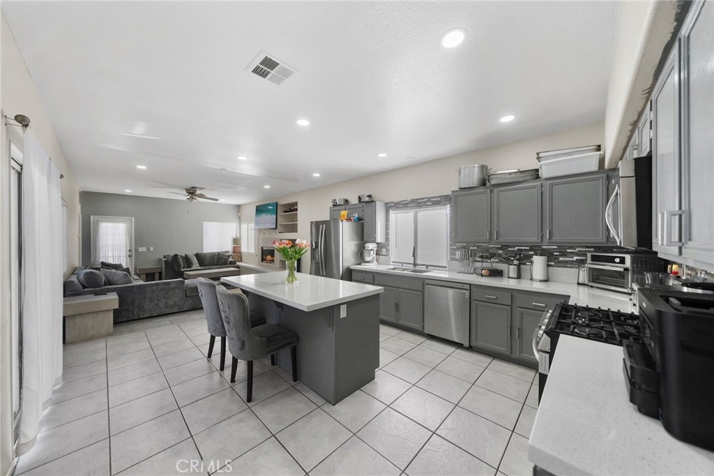 1494 Rabbit Peak Way Hemet, CA 92545 - Photo 12 of 45 a large kitchen with kitchen island a sink a counter top stainless steel appliances and cabinets