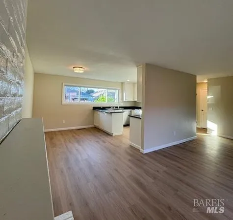 a view of kitchen and hall with wooden floor
