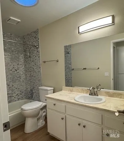 a bathroom with a granite countertop toilet a sink and a mirror