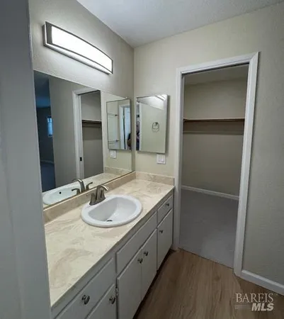 a bathroom with a granite countertop sink and a mirror
