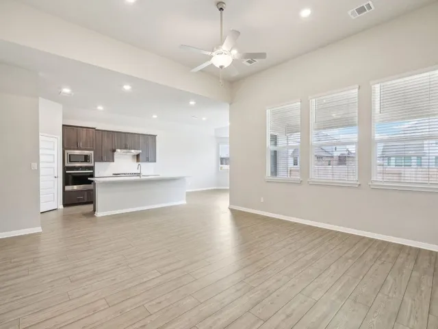a large kitchen with a large counter top a sink stainless steel appliances and cabinets