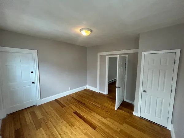 an empty room with wooden floor and closet