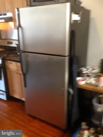 a view of a refrigerator in kitchen and wooden floor