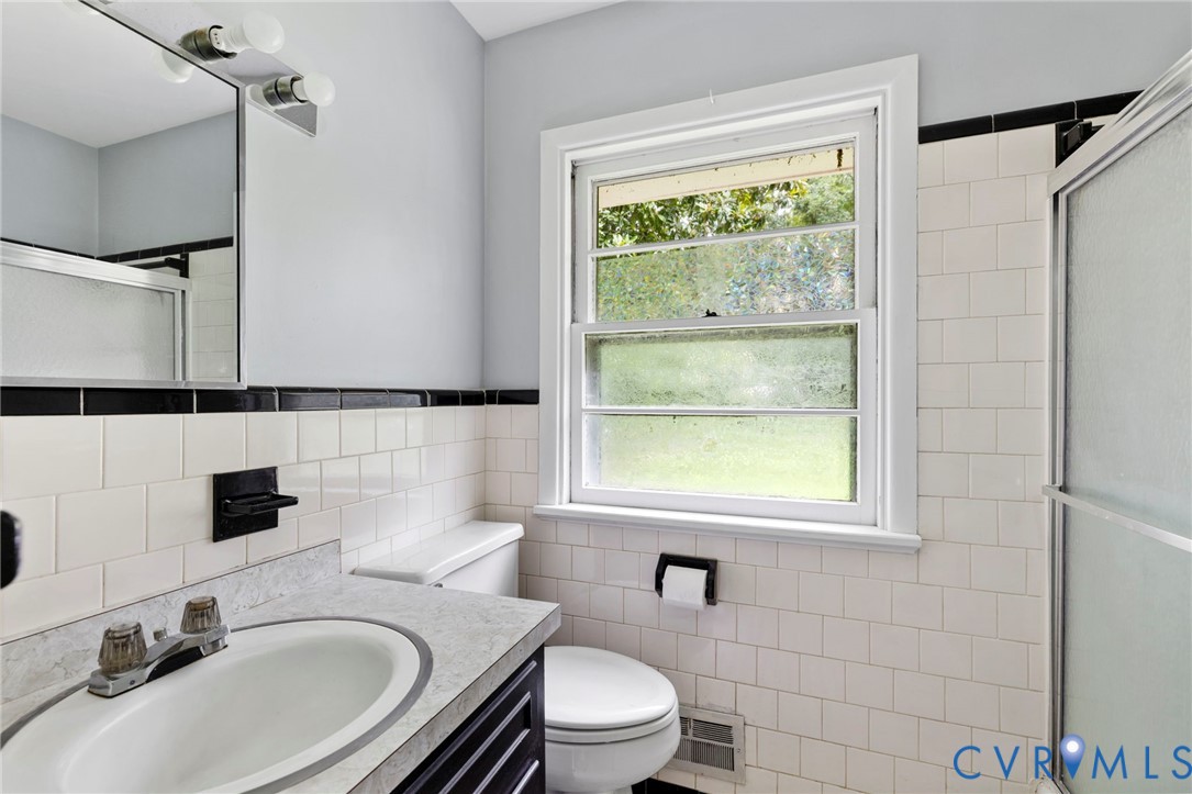11709 Boyd Road Chester, VA 23831 - Photo 15 of 32 a bathroom with a sink toilet a mirror and shower