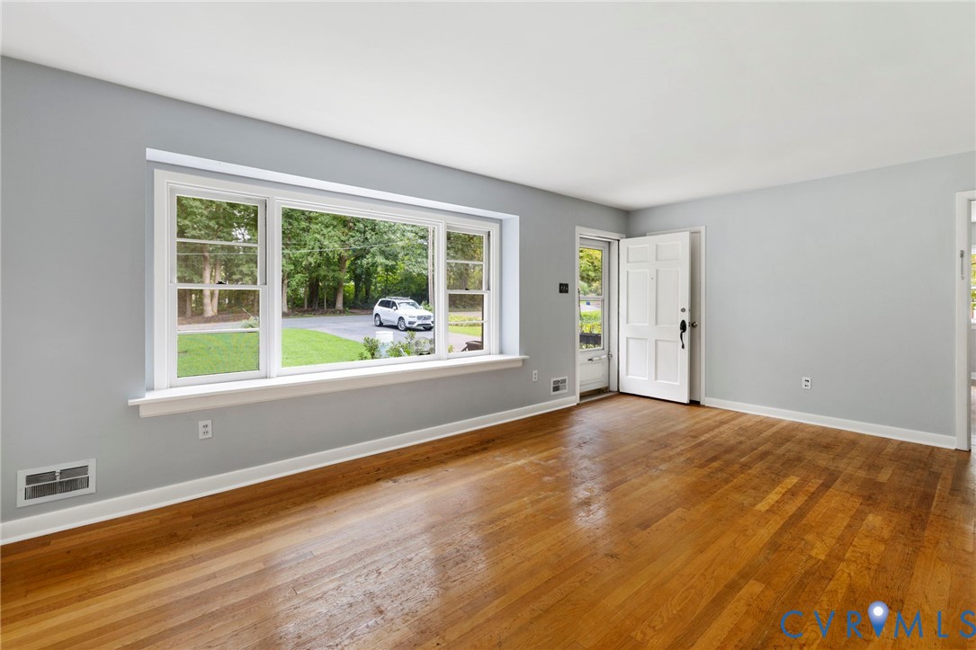 11709 Boyd Road Chester, VA 23831 - Photo 4 of 32 a view of an empty room with wooden floor and a window