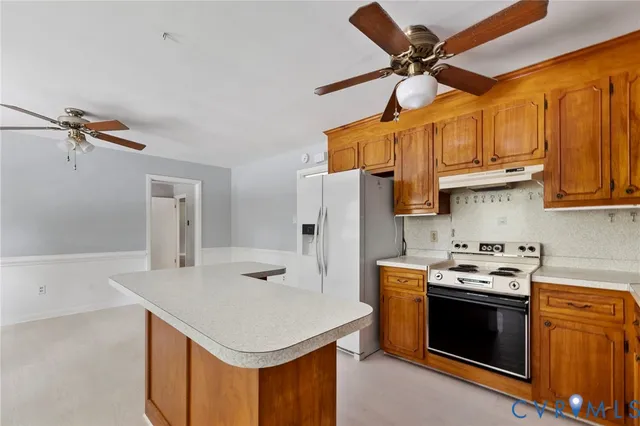 a kitchen with stainless steel appliances a stove a refrigerator a sink and white cabinets