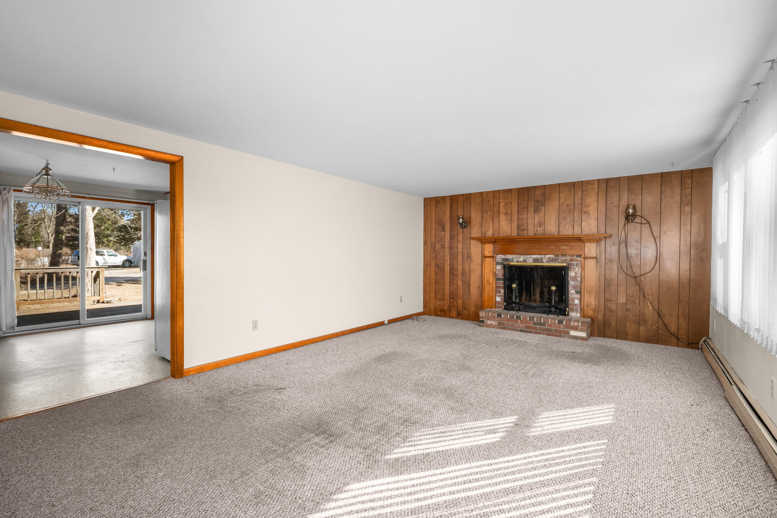5 Tonset Road Orleans, MA 02653 - Photo 7 of 33 an empty room with floor to ceiling window and fireplace