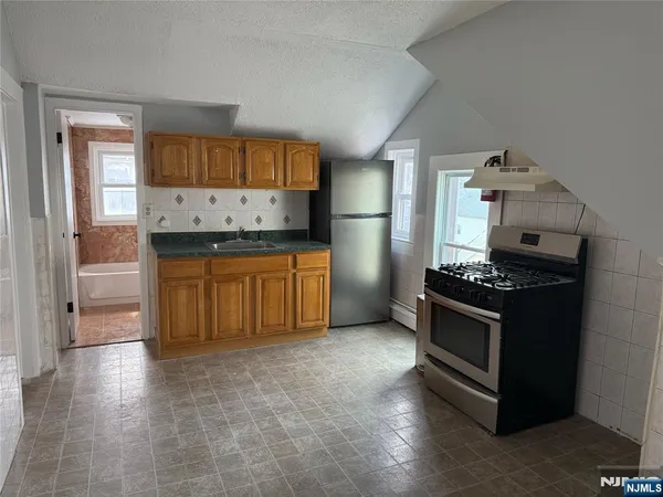 a kitchen with granite countertop a stove and a refrigerator