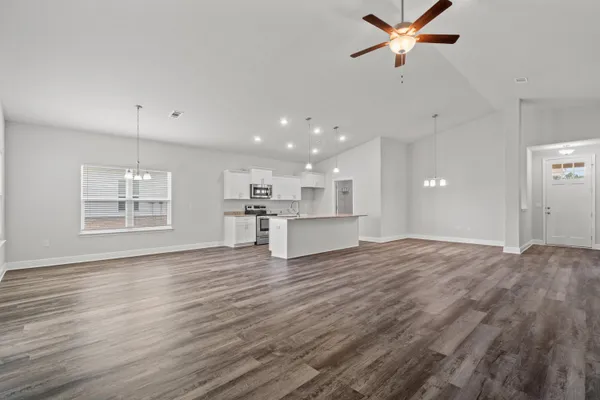a view of empty room with wooden floor and window