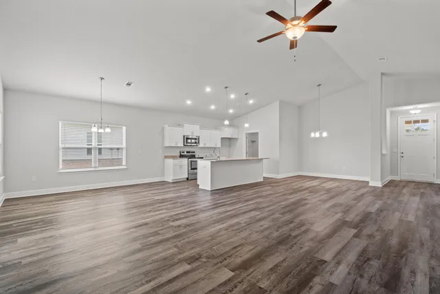 a view of empty room with wooden floor and window