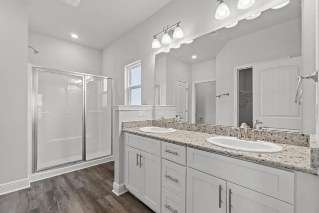 a bathroom with a granite countertop sink a large mirror and a shower