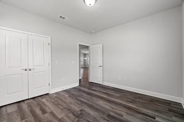 a view of an empty room with closet and a window