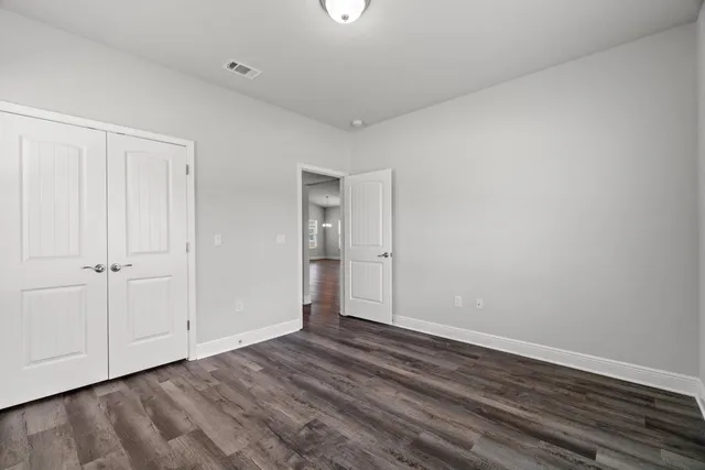 a view of an empty room with closet and a window
