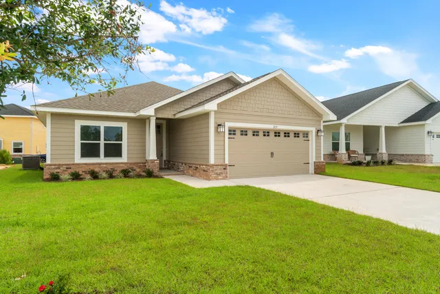 a view of a house with a big yard and large tree