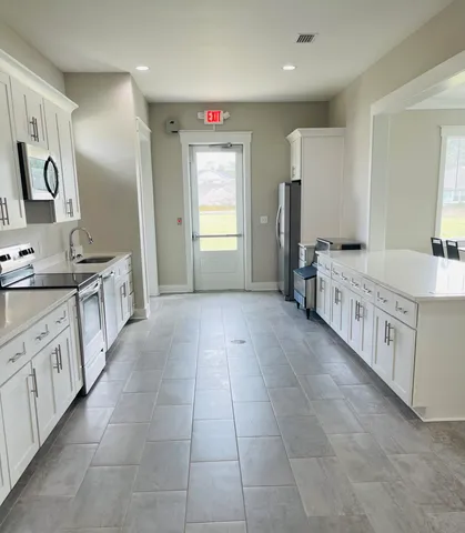 a large bathroom with a granite countertop double vanity sink a mirror and a bathtub