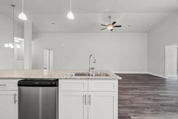 a kitchen with a sink granite counter tops and a stove