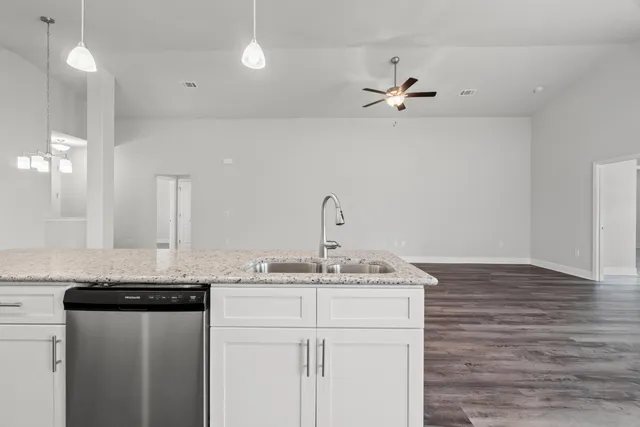 a kitchen with a sink granite counter tops and a stove
