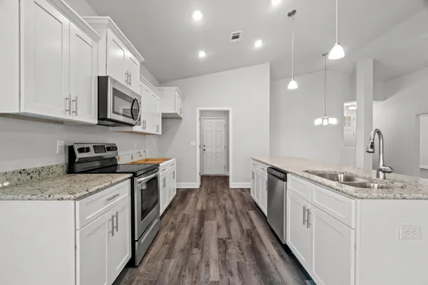 a kitchen with stainless steel appliances granite countertop a sink stove and refrigerator