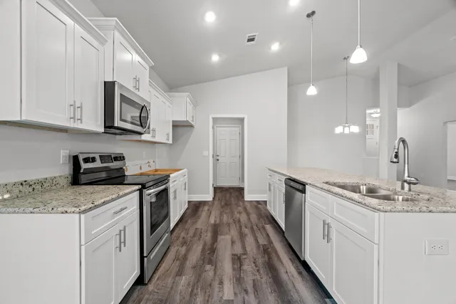 a kitchen with stainless steel appliances granite countertop a sink stove and refrigerator