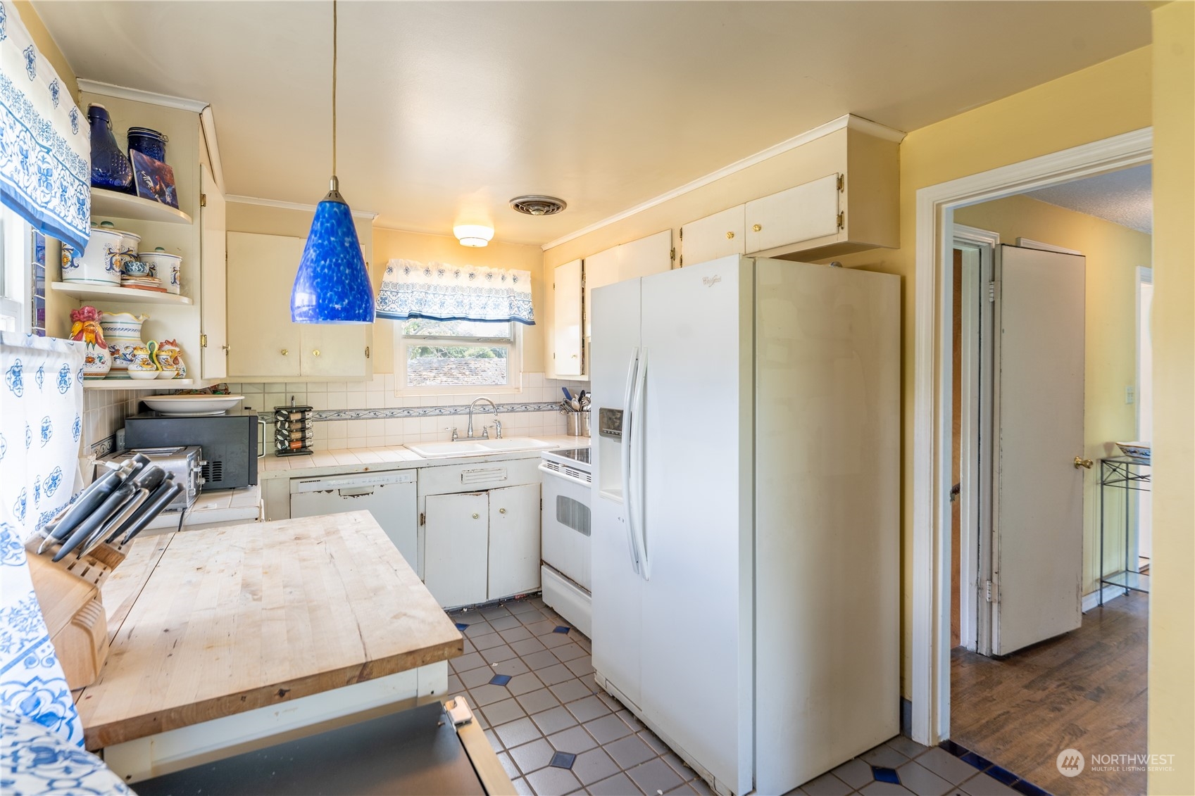 3509 Southwest Trenton Street Seattle, WA 98126 - Photo 9 of 23 a kitchen with a refrigerator a sink and white cabinets