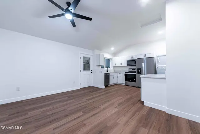 a view of kitchen with wooden floor electronic appliances and window