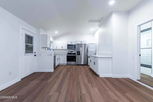 a kitchen with wooden floors and appliances