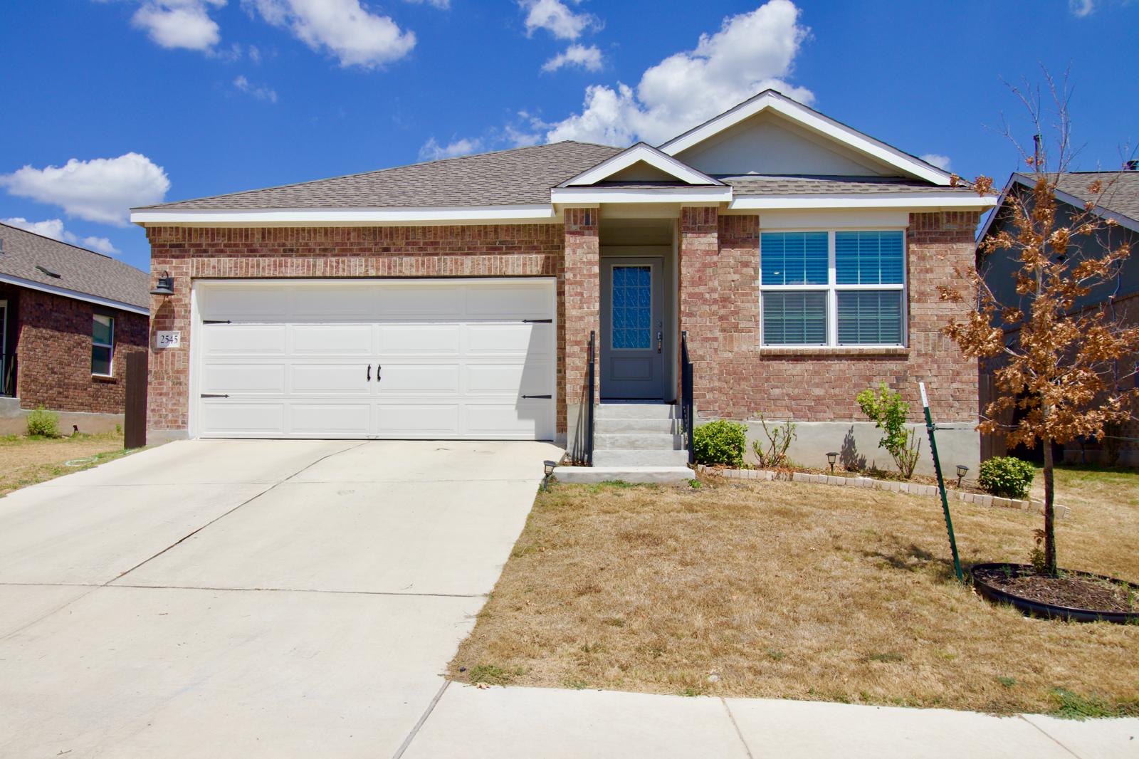 2545 Four Waters Loop Georgetown, TX 78628 - Photo 1 of 14 Classic brick craftsmanship and a concrete driveway define this single-story home design.