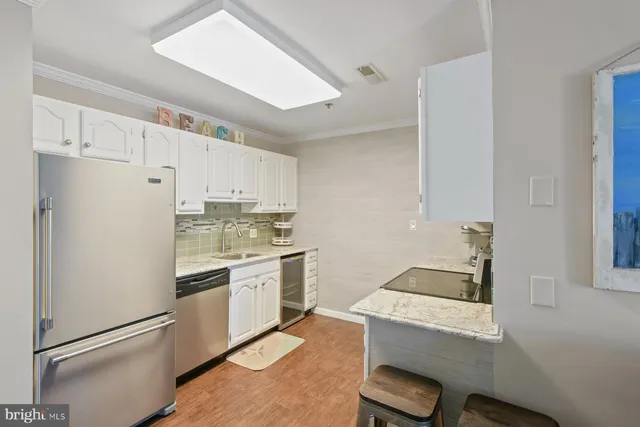 a kitchen with a stove a refrigerator and white cabinets