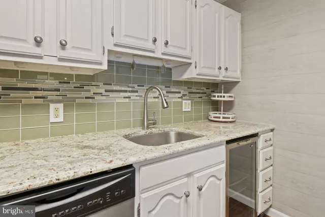 a kitchen with granite countertop a sink and cabinets