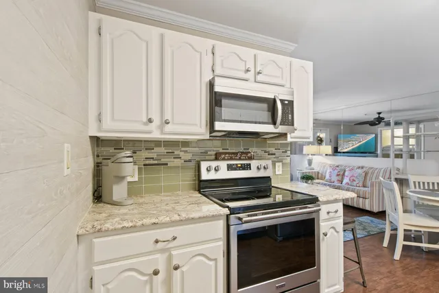 a kitchen with granite countertop a stove sink and microwave