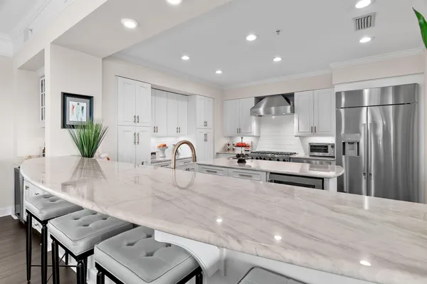 a kitchen with stainless steel appliances granite countertop a sink refrigerator and cabinets
