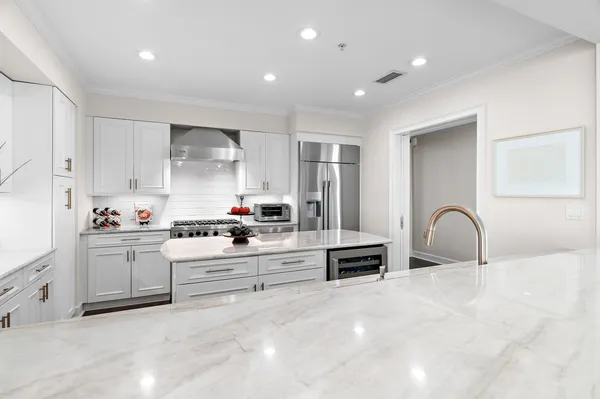 a kitchen with stainless steel appliances granite countertop a stove a sink and a refrigerator