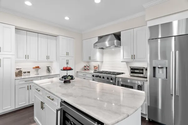 a kitchen with white cabinets and stainless steel appliances