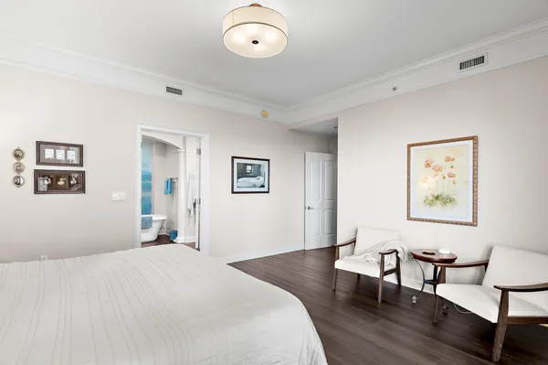 a bedroom with wooden floor and bed
