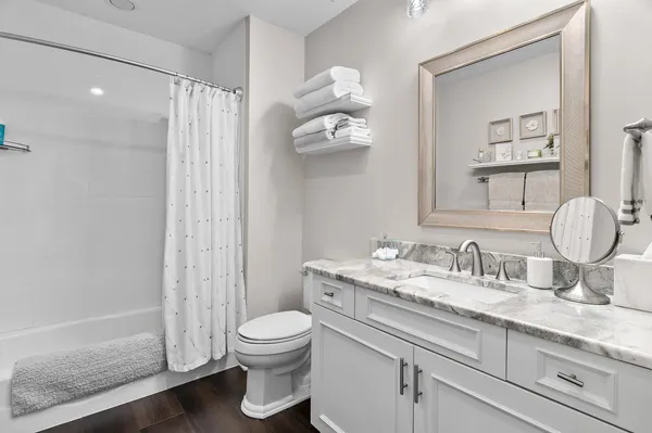 a bathroom with a granite countertop sink a toilet and a mirror