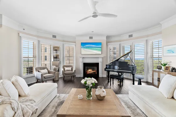 a living room with furniture a fireplace and a large window