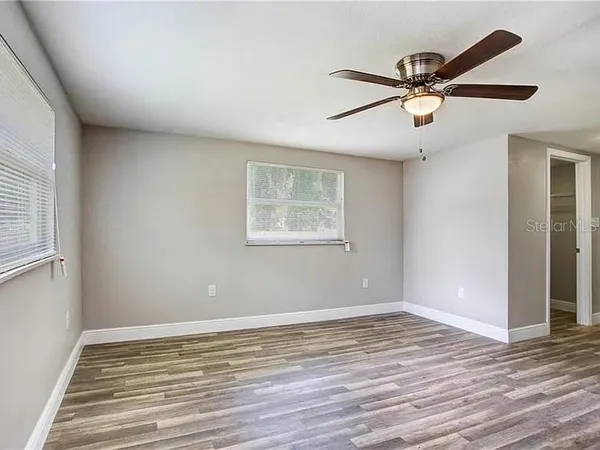 a view of a big room with wooden floor and windows