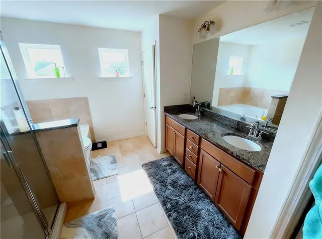 a bathroom with a tub sink and mirror