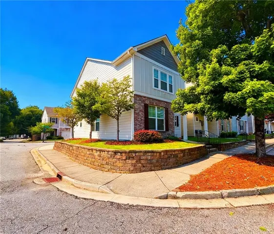 a view of a white house with a swimming pool and sitting area