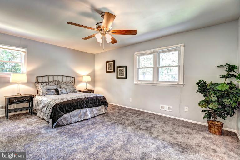 4537 Maryknoll Road Baltimore, MD 21208 - Photo 16 of 30 a spacious bedroom with a bed a chandelier and a window