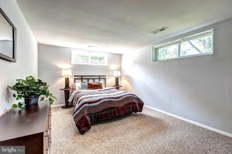 4537 Maryknoll Road Baltimore, MD 21208 - Photo 28 of 30 a bedroom with a bed potted plant on dresser and a window